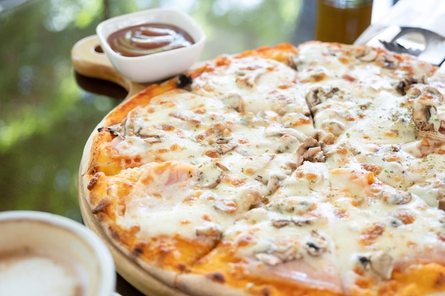 写真 ストリートカフェのガラステーブルにモッツァレラチーズを乗せたイタリアンチキンピザ