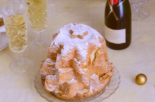 Italian christmas cake pandoro on the table with gold christmas
decoration. beautiful xmas food gatherings background