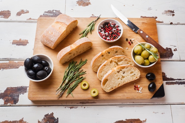 Italian ciabatta bread with olives and rosemary on a wooden Board