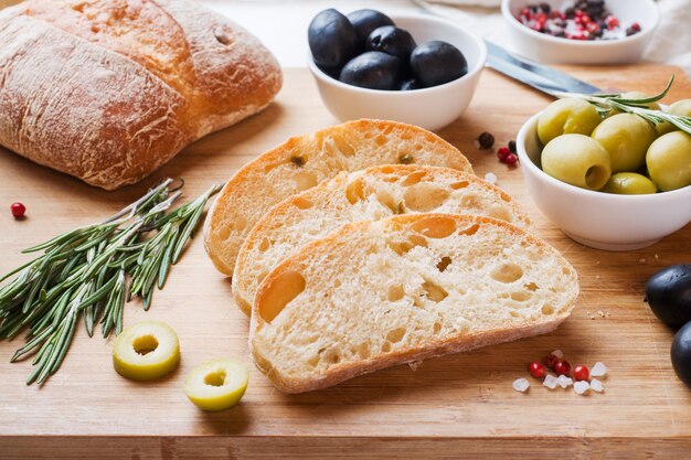 Italian ciabatta bread with olives and rosemary on a wooden Board