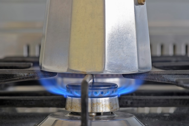 Italian coffee maker on stove with fire lit, ready to be served