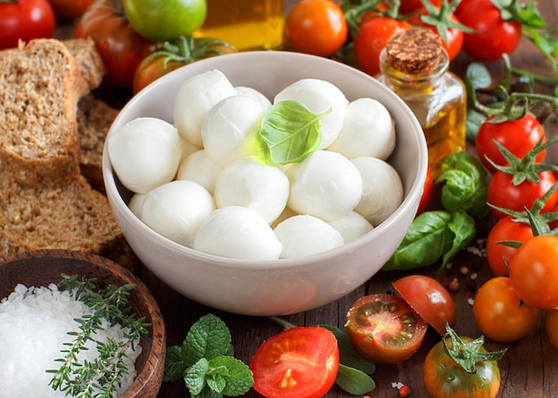 イタリア料理の材料：モッツァレラチーズ、トマト、バジル、オリーブオイルなど