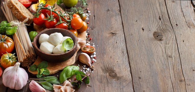 Ингредиенты для итальянской кухни, моцарелла, помидоры, чеснок, зелень, оливковое масло и др.