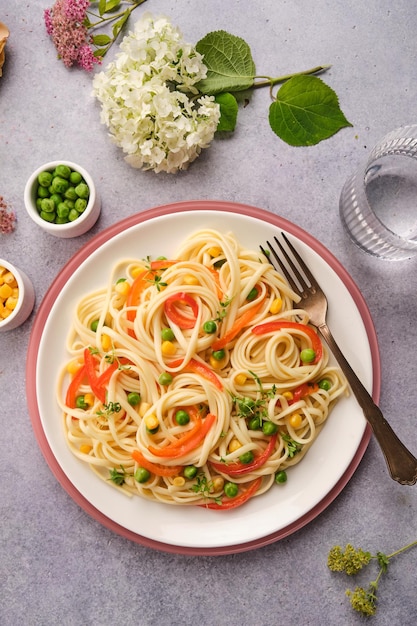 Foto cucina italiana pasta italiana fresca con piselli verdi peperoncini e mais vista dall'alto