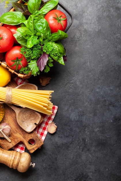 Foto ingredienti della cucina italiana pomodori da giardino pasta erbe e spezie vista dall'alto con spazio per la copia disposizione piatta