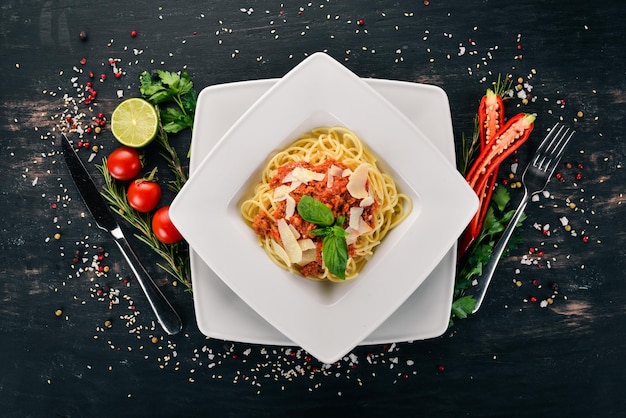 Italian cuisine pasta with tomatoes and parmesan cheese On a wooden background Top view Copy space