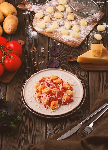 Italian dish gnocchi with tomato sauce and basil potato dumplings on a wooden table rustic no people