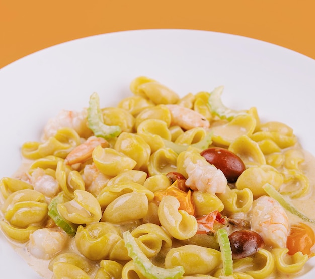 Italian dish macarana with shrimp on yellow background