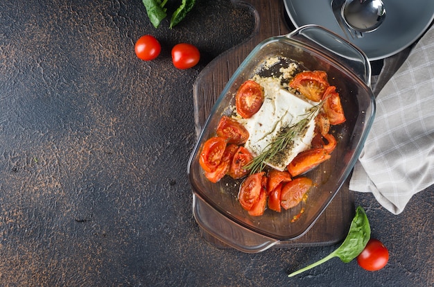 Italian dish of  pasta mixing with Feta cheese baked and tomatoes on a dark background. Fetapasta. Trending viral recipe, Flat lay, copy space