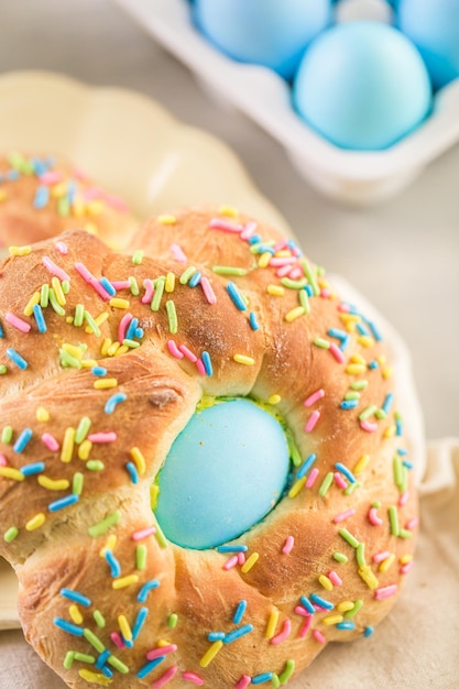 Italian Easter bread with blue colored egg and sprinkles.