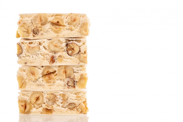 Torrone festivo italiano (o torrone) con nocciole su uno sfondo bianco