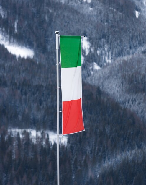 Italian flag waving by wind on pole at ski resort