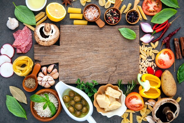 Italian food cooking ingredients on dark stone background .