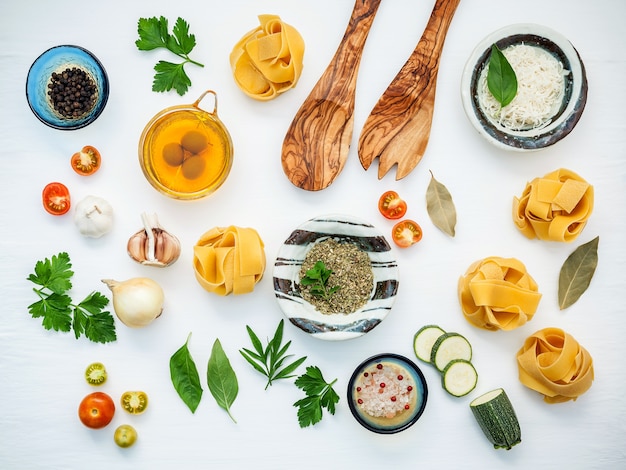 Italian food cooking ingredients on white wooden background with flat lay and copy space.