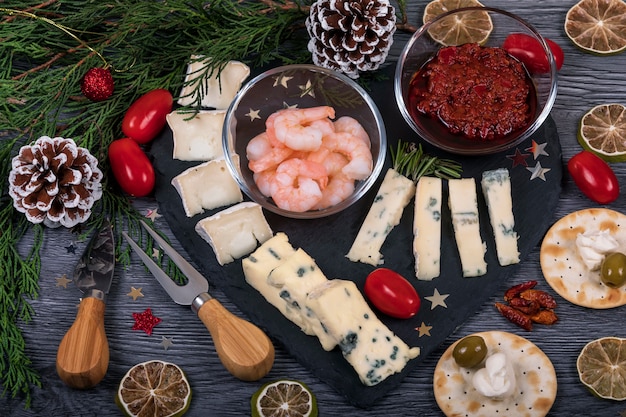 Italian food on a dark cheese platter with Christmas decor.