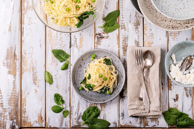 이탈리아 음식 : 신선한 집에서 만든 tagliatelle 채식 달걀 파스타 까르보나라는 흰색 나무 배경 위에 리코 타 치즈와 시금치와 함께 제공됩니다.