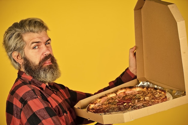 Italian food italy is here bearded male chef cook or baker man Hold italian pizza in cardboard flatbox man from delivery service happy bearded man with pizza