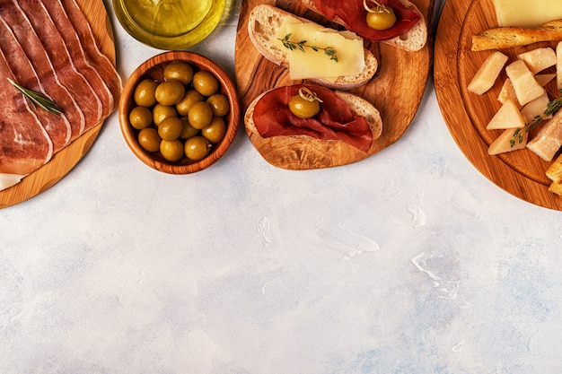 Italian food table with ham, cheese, olives.