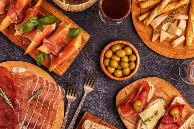 Italian food table with ham, cheese, olives.