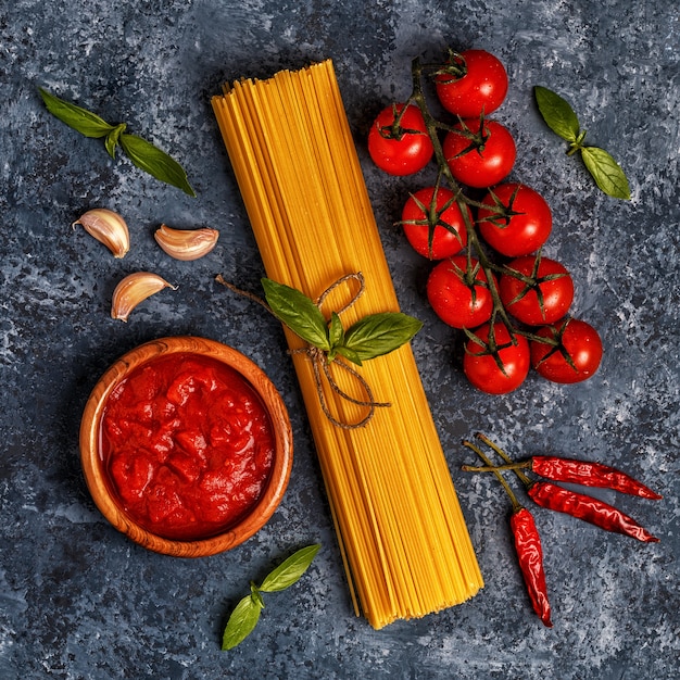 Italian food table with pasta, spices and vegetables.