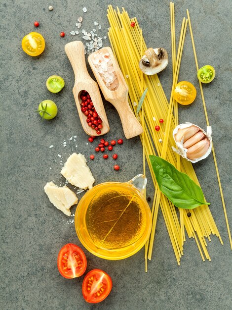 Italian foods concept and menu design. Pasta with ingredients on stone background .