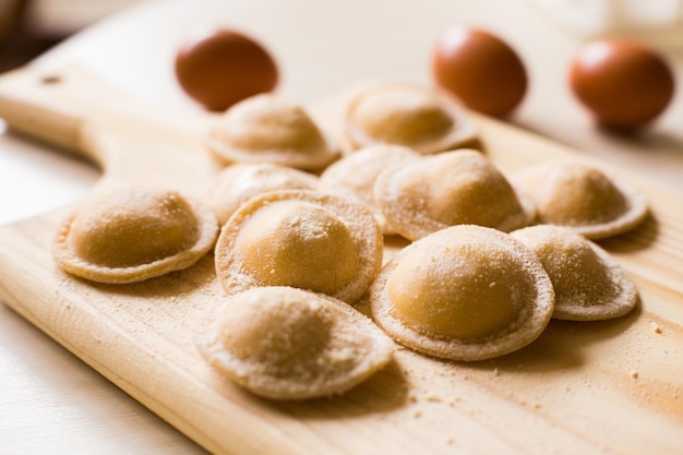 Italian fresh pasta. Panzerotti made by hand on a wooden board.