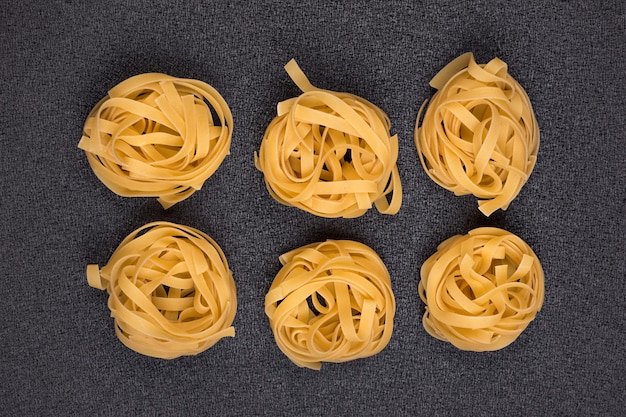 Fettuccine rotolati freschi italiani di fettuccine su fondo grigio