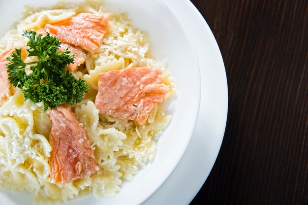 Italian fried salmon and penne rigate with creamy spinach alfredo pasta sauce