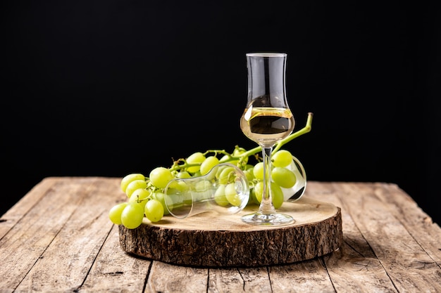 Italian golden grappa drink on wooden background