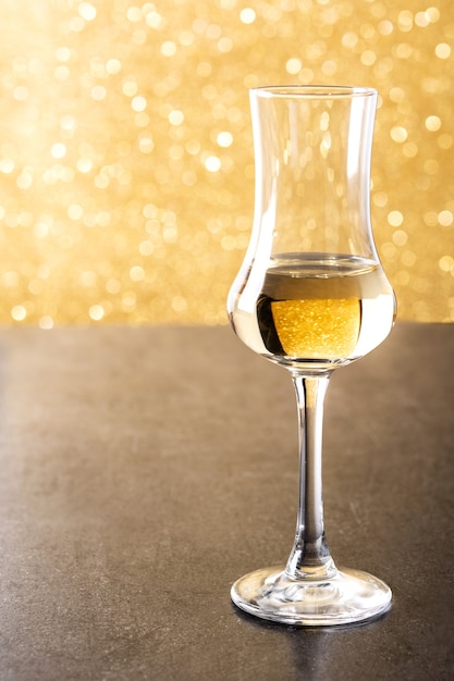 Foto bevanda grappa d'oro italiana su sfondo giallo brillante