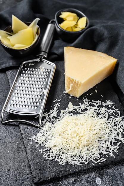 Фото Ломтик итальянского твердого сыра пармезан, нарезанный, тертый