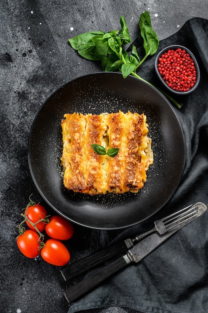 Italian homemade pasta cannelloni with beef and tomato sauce. top view