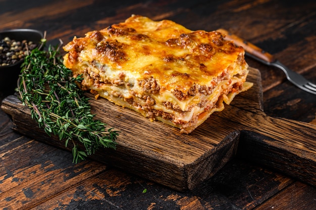 Italian Lasagna with bolognese sauce and mince beef meat. Dark Wooden background. Top view.