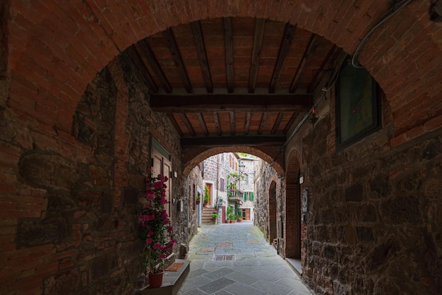 Dettagli del borgo medievale italiano storico arco in pietra antica porta della città vecchia edifici in pietra architettura radicofani toscana italia