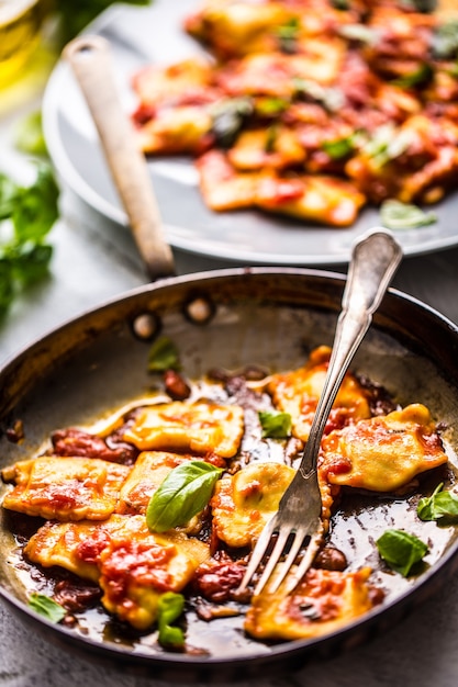 Italian or mediterranean food pasta ravioli of tomato sauce and basil.