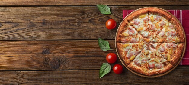 Italian melted cheese pizza on a black table with food ingredients cherry tomatoes and rosemary C