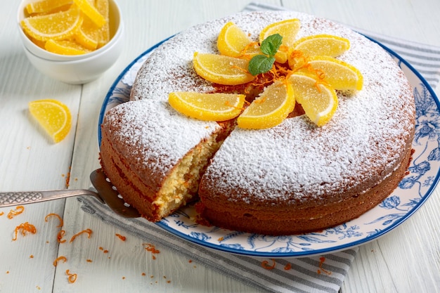 Italian orange cake decorated with powdered sugar and marmalade slices