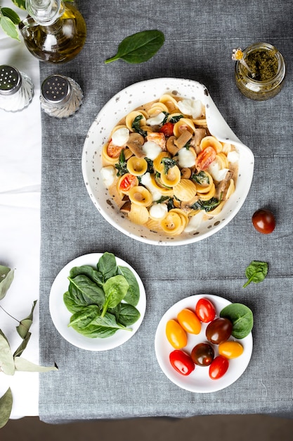 Orecchiette italiane con spinaci, pomodori e mozzarella