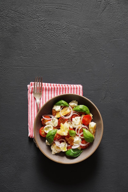 italian panzanella salad in bowl on dark background top view place for text