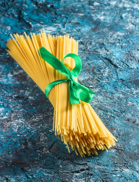 Italian pasta on a blue concrete table. Top view