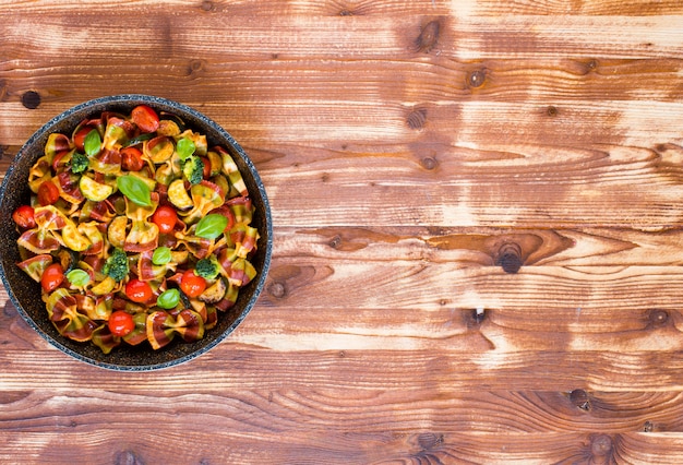 Italian pasta farfalle in tomato sauce and various type of vegetables 