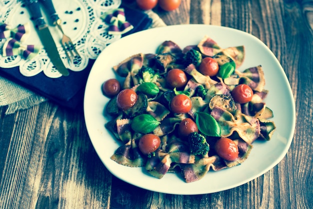 Italian pasta farfalle in tomato sauce and various type of vegetables