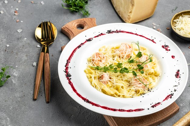Итальянская паста феттучини в сливочном соусе с креветками с сыром и микрогрином Меню ресторана диета поваренная книга рецепт вид сверху