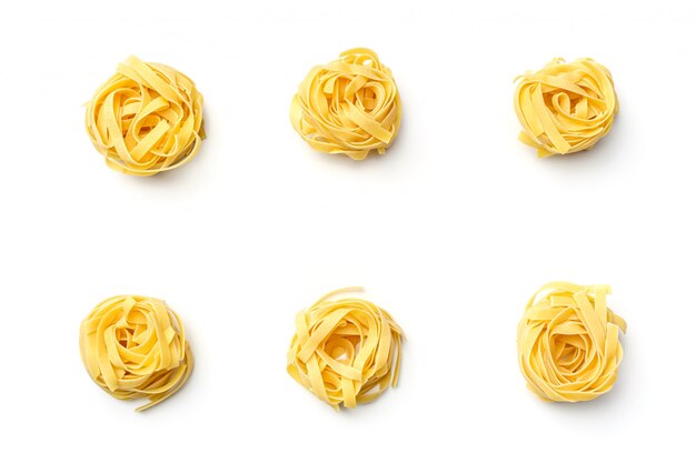 Nido italiano del fettuccine della pasta isolato su fondo bianco