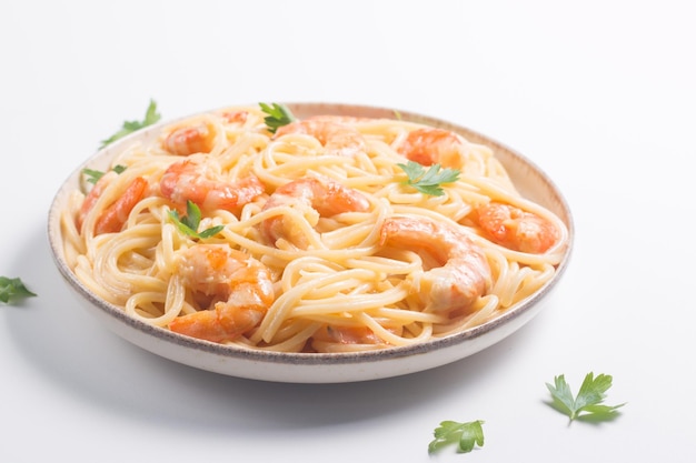 Italian pasta fettuccine or spaghetti in a creamy cheese sauce with shrimp or prawns on a plate