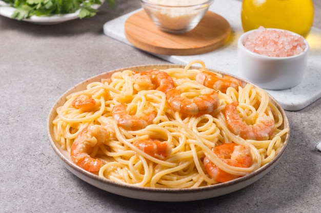 Italian pasta fettuccine or spaghetti in a creamy cheese sauce with shrimp or prawns on a plate