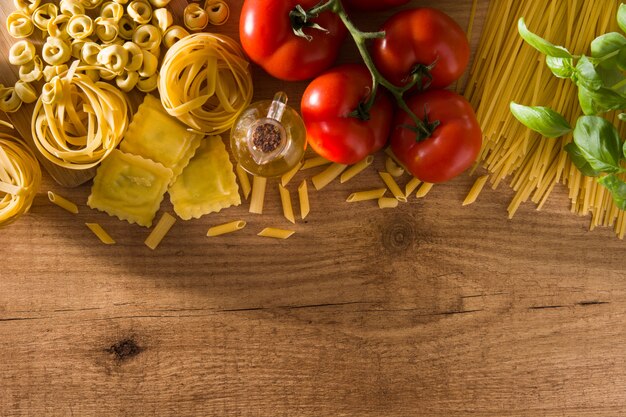 イタリアのパスタと食材。ラビオリ、ペンネパスタ、スパゲッティ、トルテリーニ、トマト、バジル