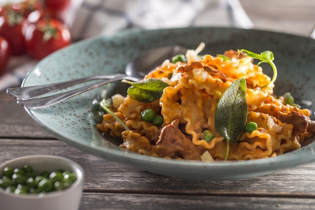 Italian pasta mafalde mushrooms peas and tomato sauce.