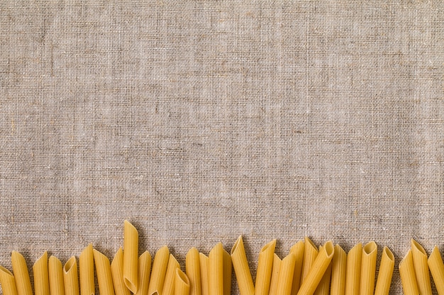 Italian pasta penne on a gray background