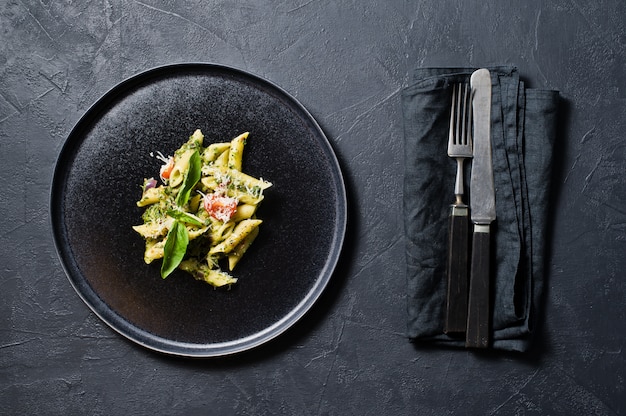 Photo italian pasta penne with spinach, cherry tomatoes and basil. ingredients for cooking.